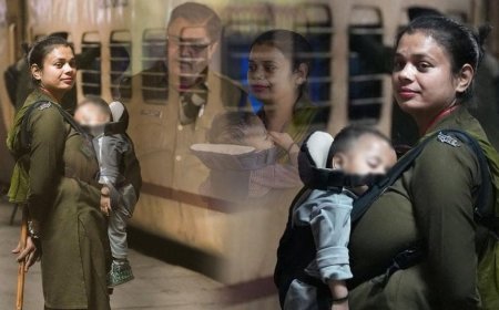 Female constable working with baby held close to her chest